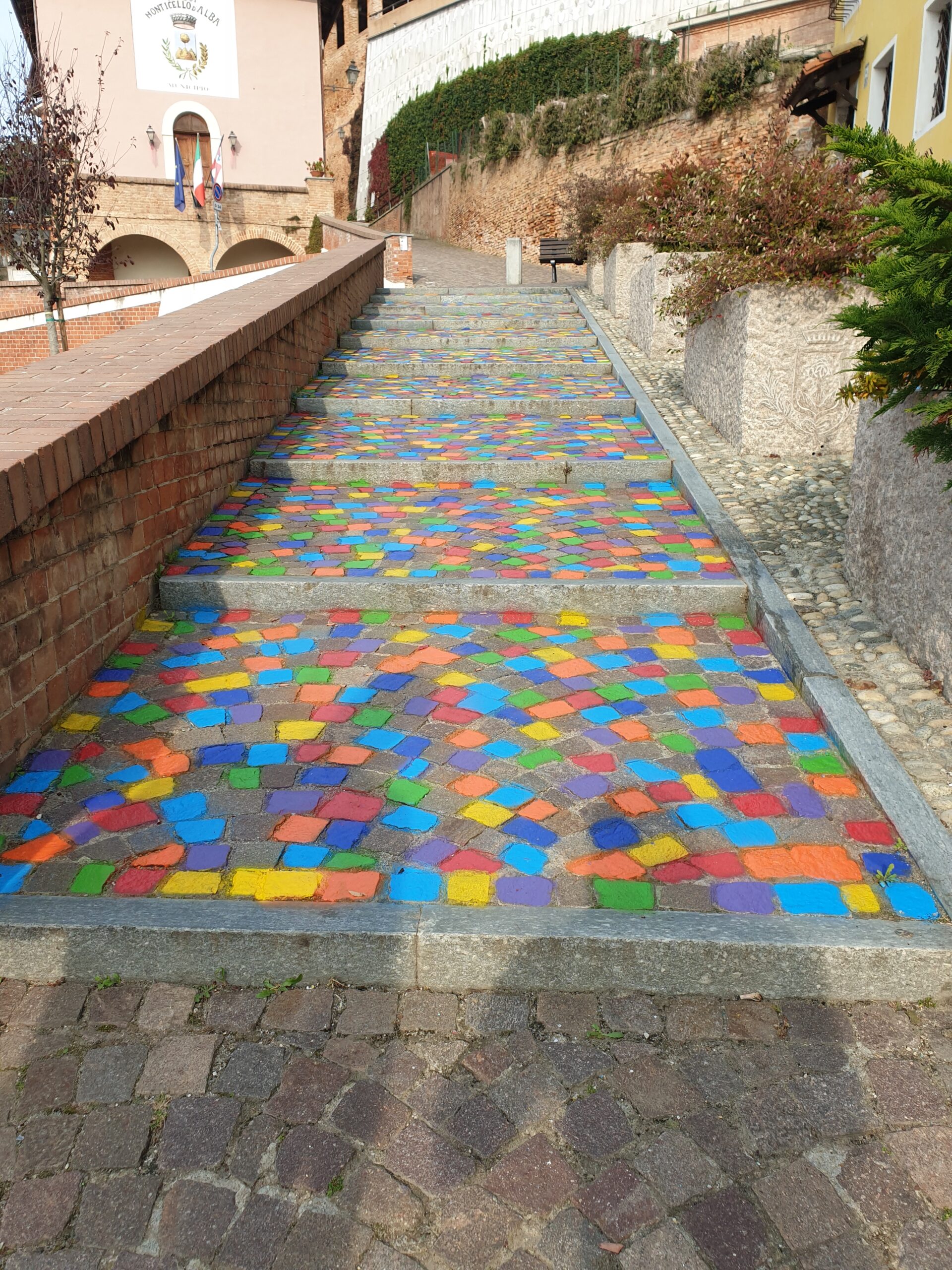 Opera di Land Art “Meditaçion” a Monticello d’Alba (CN), installazione di land art con sanpietrini colorati a spirale, percorso simbolico tra dimensione spirituale e materiale, arte ambientale contemporanea con geometrie circolari e colori vibranti.