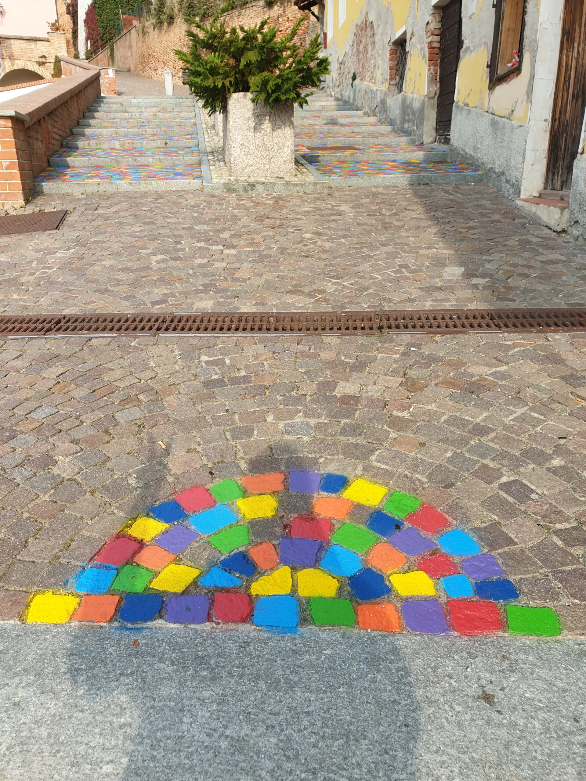 Opera di Land Art “Meditaçion” a Monticello d’Alba (CN), installazione di land art con sanpietrini colorati a spirale, percorso simbolico tra dimensione spirituale e materiale, arte ambientale contemporanea con geometrie circolari e colori vibranti.