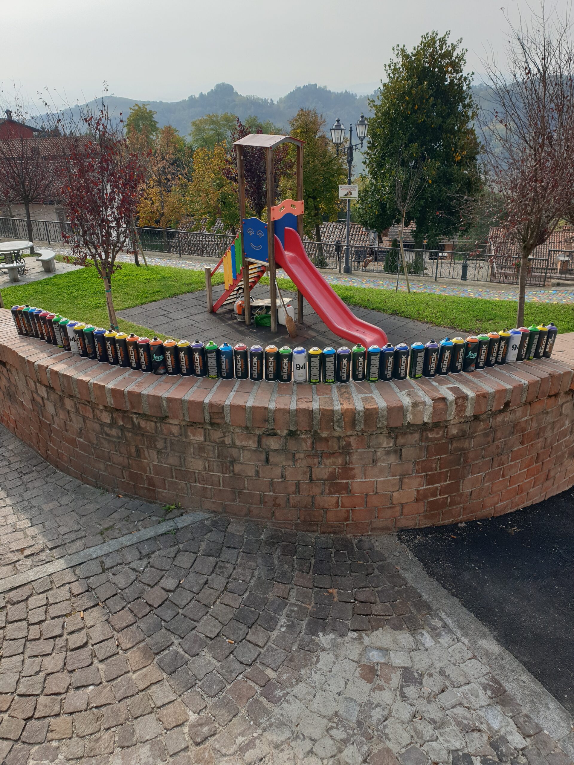 Opera di Land Art “Meditaçion” a Monticello d’Alba (CN), installazione di land art con sanpietrini colorati a spirale, percorso simbolico tra dimensione spirituale e materiale, arte ambientale contemporanea con geometrie circolari e colori vibranti.